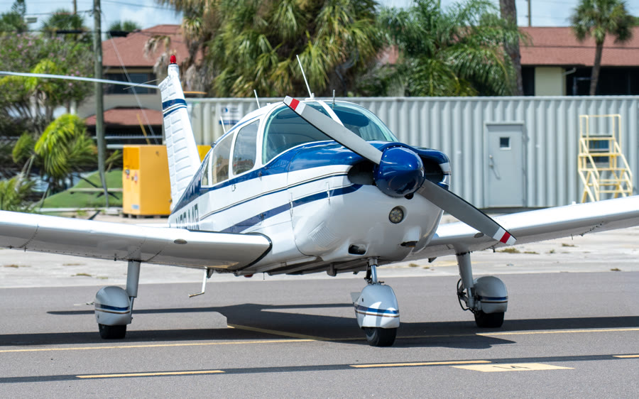 The Alpha Company Aviation Piper Cherokee, a blue and white low-wing four-seat trainer, on the ramp at Venice Municipal Airport