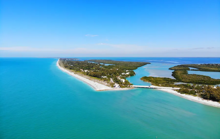 Aerial view of a Florida Gulf Coast barrier island and blue water, near the Sarasota flight school area in Venice, FL