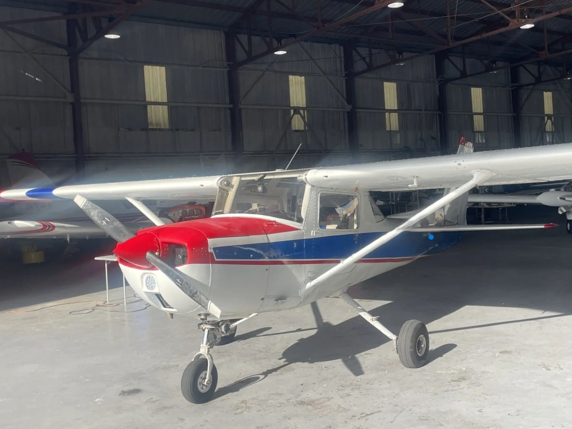 A Cessna 150 flight training aircraft inside the Alpha Company Aviation hangar